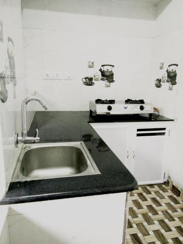 a kitchen with a sink and a stove at Nunu Homestay Guruvayoor in Guruvāyūr