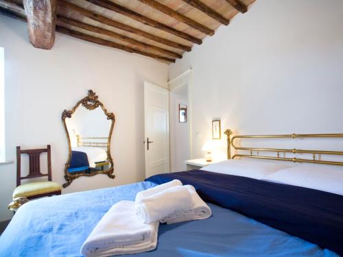 a bedroom with a bed with blue sheets and a mirror at Nonna Pappa in Siena