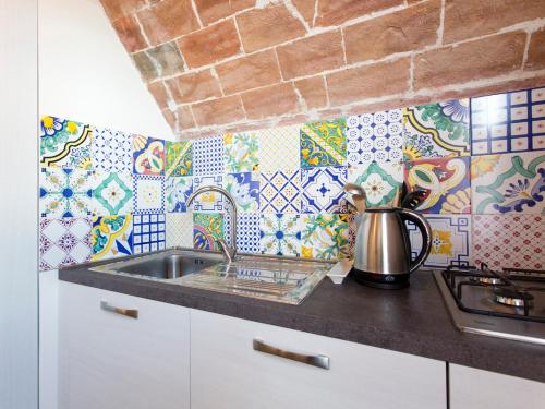 a kitchen with a sink and a tile wall at Nonna Pappa in Siena