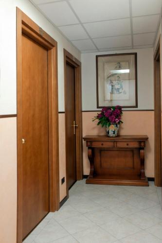 a hallway with a vase of flowers on a table at Hotel Boston in Stresa