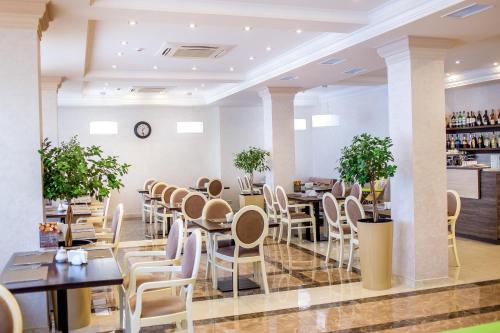 a restaurant with tables and chairs and a bar at Green Park Hotel & SPA in Truskavets
