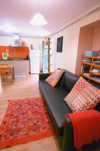 a living room with a black couch and a kitchen at Moinho do Prado in Vila Nova de Cerveira