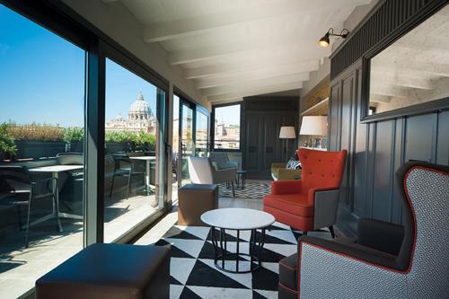 a room with a balcony with chairs and a table at Trianon Borgo Pio Aparthotel in Rome