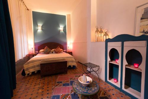 a bedroom with a bed and a table in it at Riad El Ma in Meknès