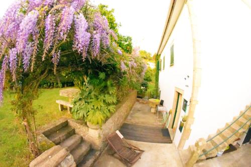 a garden with purple flowers on a building at Moinho do Prado in Vila Nova de Cerveira