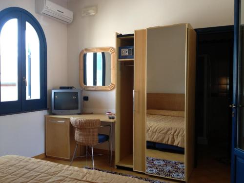 Hotel Aura في فولكانو: غرفة بها سرير ومكتب وبه جهاز كمبيوتر