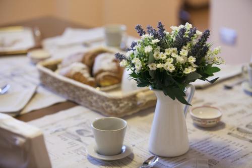 a table with a vase of flowers and a basket of pastries at B&B Al Colle in Pescosolido