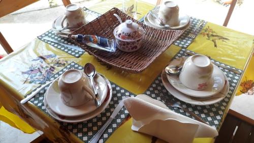 a table with plates and cups and spoons on it at Pousada Terra Boa in Paraty