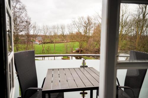 a table and chairs on a balcony with a view of a field at Lindenhof Habernis in Steinberg