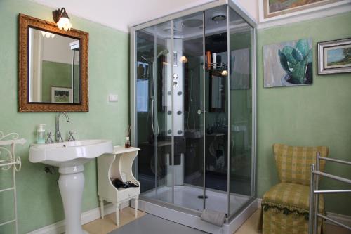 a bathroom with a glass shower and a sink at Masnadieri 18 in Parma