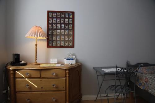 a lamp on top of a dresser next to a desk at Masnadieri 18 in Parma