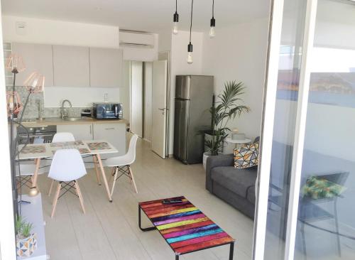uma cozinha e sala de estar com um sofá e uma mesa em CALVI em Calvi