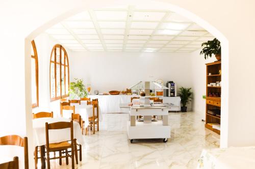 a kitchen with a table, chairs and a refrigerator at Hôtel les Arbousiers in Calvi