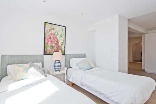 een slaapkamer met twee bedden en een lamp op een tafel bij Cubo in Sintra