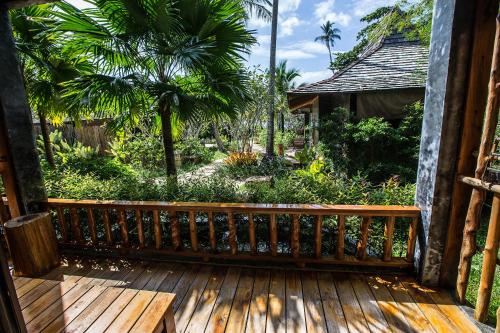 a wooden deck with a view of a garden at Andalay Beach Resort Koh Libong in Ko Libong