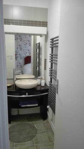 une salle de bain avec un lavabo et un miroir dans l'établissement studio mer, à Saint-Malo