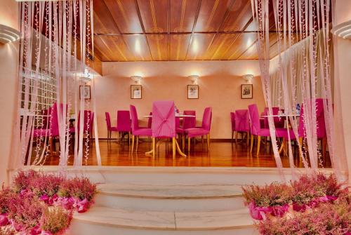 a dining room with pink chairs and a table at Hotel San Giusto in Trieste