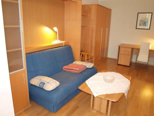 a living room with a blue couch and a table at Kurpark Appartements in Bad Hofgastein