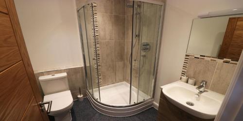 a bathroom with a shower and a toilet and a sink at Yachtsmans Rest in Falmouth