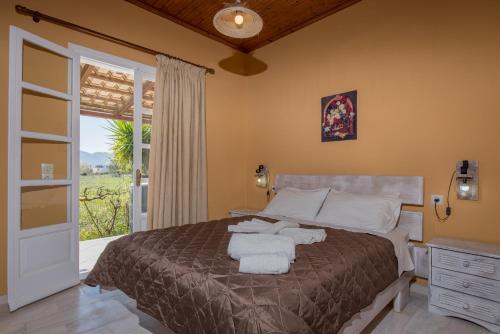 1 dormitorio con 1 cama con toallas en Augoustinos Villa, en Zakynthos