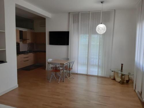 eine Küche und ein Esszimmer mit einem Tisch und einem TV in der Unterkunft Residenza Villa Cristalli in Piacenza
