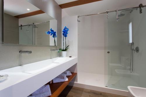 y baño con lavabo y ducha. en Hotel Ca Marí, en Playa de Migjorn