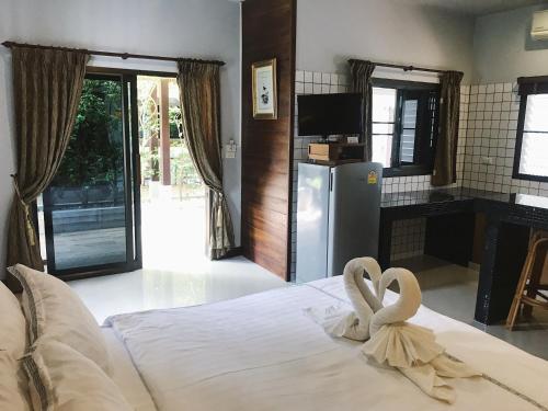 a bedroom with a bed with two swans on it at The Nest Samui in Bang Rak Beach