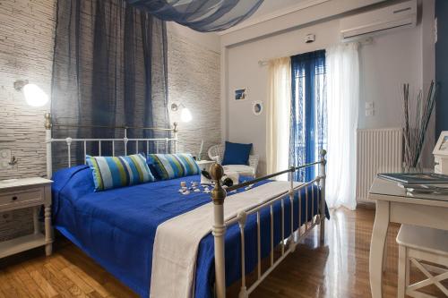 a bedroom with a bed with a blue comforter at Pretty rooms in Gold and Blue apartment in safe central area in Athens