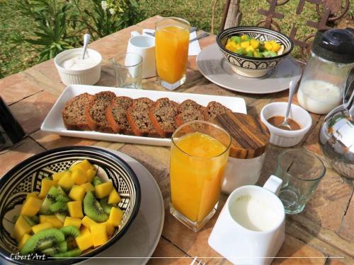a table with plates of food and fruit on it at Libert'Art in Essaouira