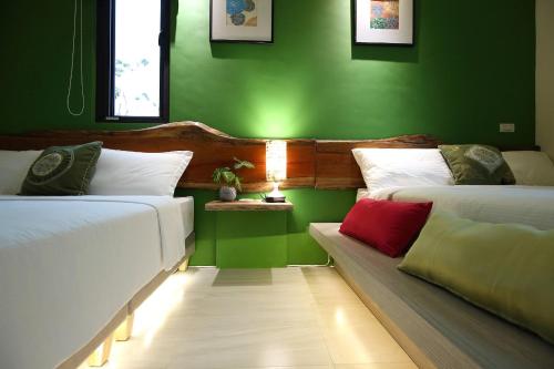 two beds in a room with green walls at Manor Le Rayon Vert in Jian