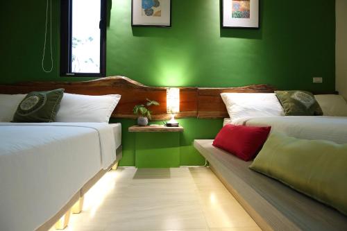 - 2 lits dans une chambre aux murs verts dans l'établissement Manor Le Rayon Vert, à Jian
