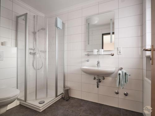 a bathroom with a shower and a sink and a toilet at Café-Pension Endehof in Oberprechtal