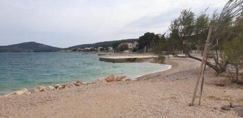 a beach with rocks and a body of water at ZEN MURTER Mobil home in Betina