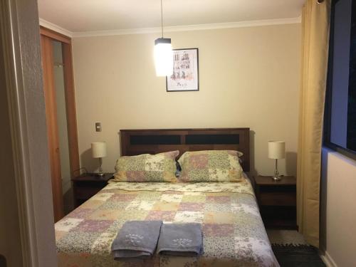 un dormitorio con una cama con dos almohadas en Parque del Volcan Pucon, en Pucón