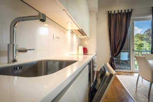 eine Küche mit einem Waschbecken und einer Theke mit einem Fenster in der Unterkunft Porto Montenegro Tara 302 in Tivat