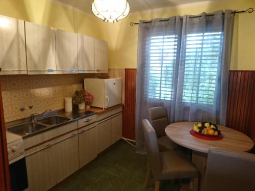 a kitchen with a table with a bowl of fruit on it at Kuća za odmor Magdalena in Vrtlinovec
