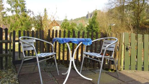 two chairs and a table in front of a fence at Pension "Lug ins Land" in Kurort Rathen