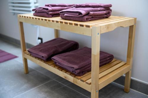 a wooden shelf with purple towels on it at B&B Hof ter Kouter in Dworp