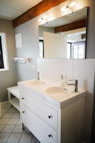 a bathroom with two sinks and a large mirror at Landhaus Habernis in Steinberg
