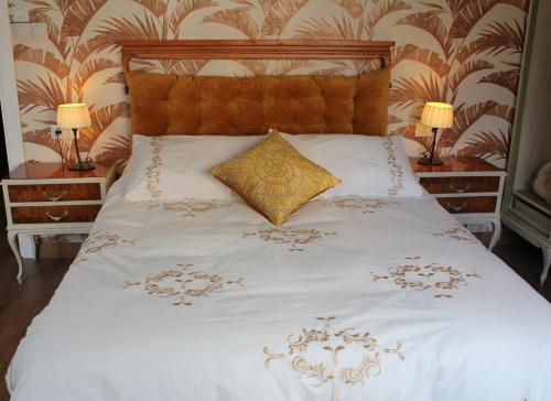 a white bed with a gold pillow on it at Mía's Home in León