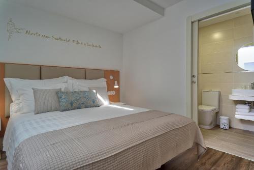 a bedroom with a large bed with a blue pillow at Alojamento da Vila in Valença