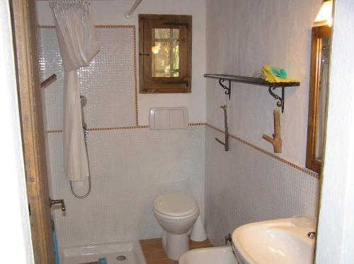 Un baño con inodoro, ducha y lavabo. en Bamboo House, en Teulada
