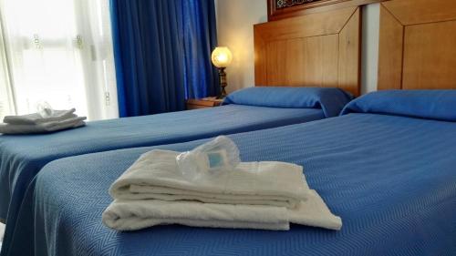 a hotel room with two beds with towels on them at Casa David in Tríacastela