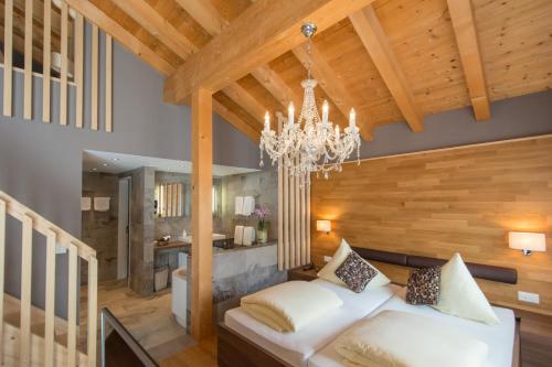 a living room with a large white couch and a chandelier at Hotel La Cruna in Sedrun