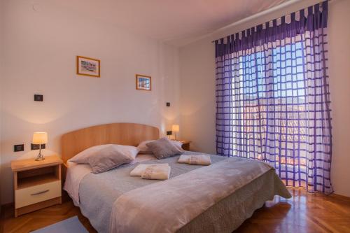 a bedroom with a large bed and a large window at Apartment Medak in Cres