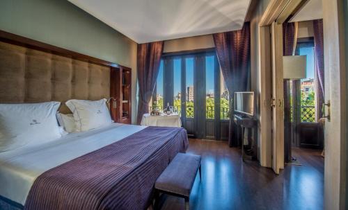 a bedroom with a bed and a window with a view at Hotel Casa Fuster G.L Monumento in Barcelona