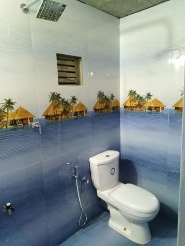 a bathroom with a toilet and some huts at Ceylon Antheia Beach Resort in Nilaveli