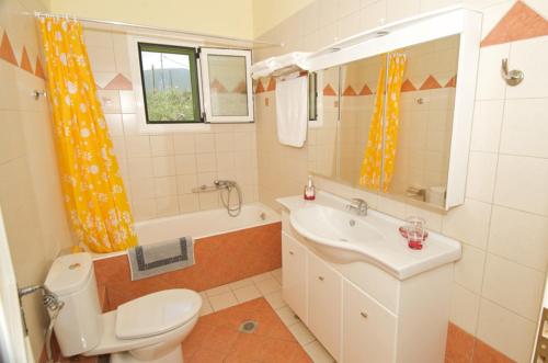 Un baño con un inodoro blanco y un lavabo. en Iliachtides Villas, en Karavomylos