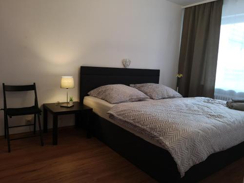 a bedroom with a bed and a chair and a window at Family Suites & Parking in Baden-Baden
