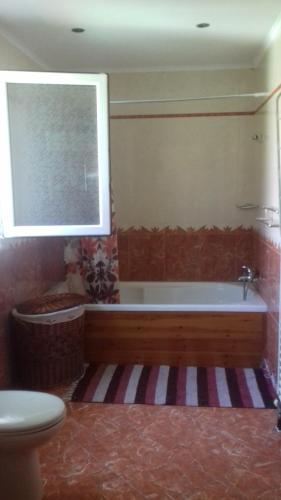 bagno con vasca, servizi igienici e finestra di Christina 's House a Alykes